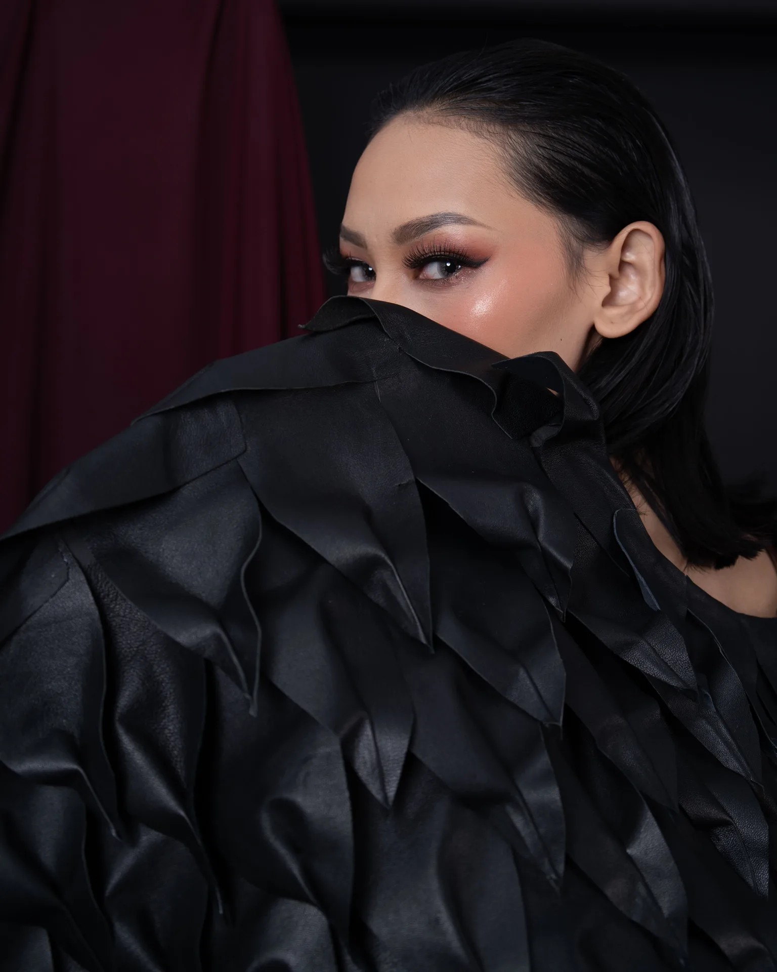 Gina looking over a dramatic black feathered collar